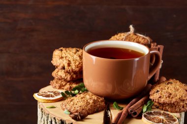 Bir fincan sıcak çay, kurabiye ve dekorasyon ahşap arka plan, seçici odak üzerinde bir oturum ile Noel kavramı