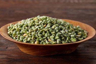 Rustik arka plan, yakın çekim, seçici odak, sığ derinlik-in tarla ahşap bir plaka üzerinde ham yeşil bezelye.