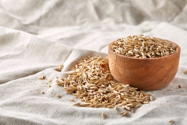 Yulaf kabuğu çıkarılmış tane veya yulaf ani artış ahşap plaka saf masa örtüsü arka plan, kopya alanı, üstten görünüm seçici odak üzerinde