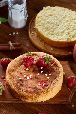 Lezzetli pasta kesme tahtası üzerinde ahşap arka plan, yakın çekim, selctive odak üzerinde taze organik çilek ile.