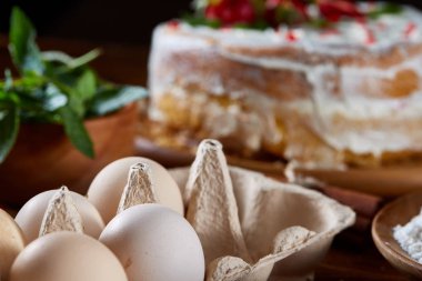 Çilekli tart ahşap arka plan üzerinde düz yatıyordu organik maddeler tarafından çevrili ekşi krem şanti ile kaplı.