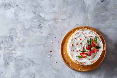 Çilek ve beyaz dokulu arka planda, seçici odak nane yaprakları ile süslenmiş krem şanti ile tart