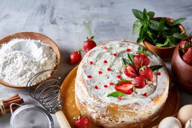 Çilekli tart beyaz arka plan üzerinde düz yatıyordu organik maddeler tarafından çevrili ekşi krem şanti ile kaplı.