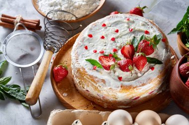 Çilekli tart beyaz arka plan üzerinde düz yatıyordu organik maddeler tarafından çevrili ekşi krem şanti ile kaplı.