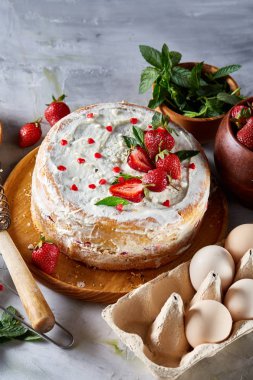 Çilekli tart beyaz arka plan üzerinde düz yatıyordu organik maddeler tarafından çevrili ekşi krem şanti ile kaplı.