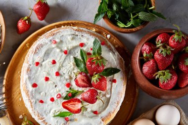 Çilekli tart beyaz arka plan üzerinde düz yatıyordu organik maddeler tarafından çevrili ekşi krem şanti ile kaplı.