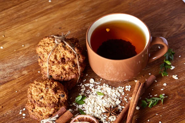 Bir fincan sıcak çay, kurabiye ve dekorasyon ahşap arka plan, seçici odak üzerinde bir oturum ile Noel kavramı