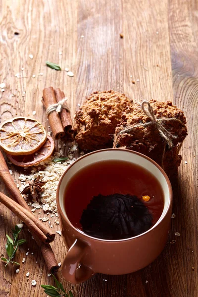 Bir fincan sıcak çay, kurabiye ve dekorasyon ahşap arka plan, seçici odak üzerinde bir oturum ile Noel kavramı