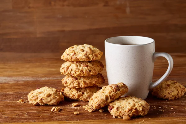 Beyaz porselen kupa çay ve tatlı kurabiye ahşap arka plan, üstten görünüm, seçici odak