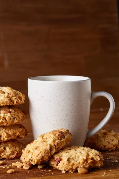Beyaz porselen kupa çay ve tatlı kurabiye ahşap arka plan, üstten görünüm, seçici odak