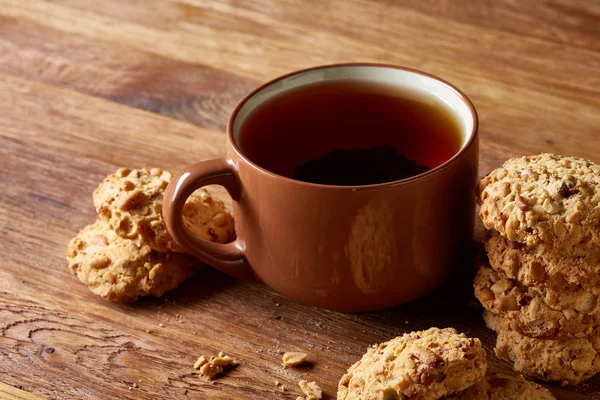 Porselen fincan çay ve tatlı kurabiye ahşap arka plan, üstten görünüm, seçici odak