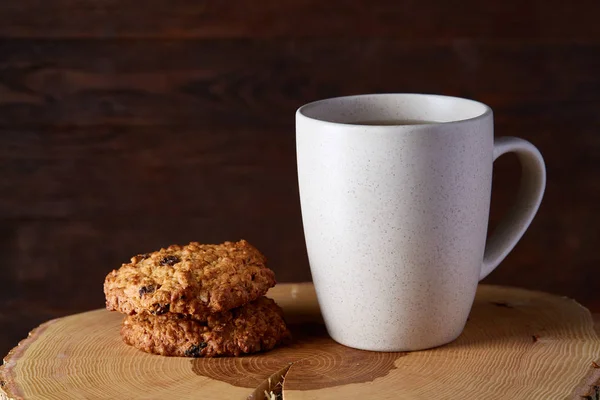 Beyaz porselen kupa çay ve tatlı kurabiye ahşap arka plan, üstten görünüm, seçici odak