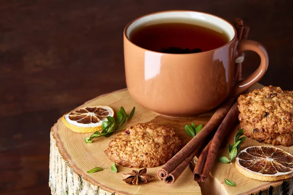 Bir fincan sıcak çay, kurabiye ve dekorasyon ahşap arka plan, seçici odak üzerinde bir oturum ile Noel kavramı