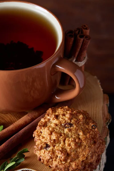 Concetto natalizio con una tazza di tè caldo, biscotti e decorazioni su uno sfondo di legno, messa a fuoco selettiva — Foto Stock