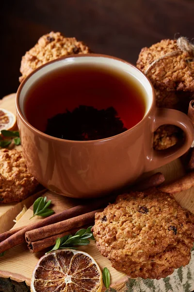 Bir fincan sıcak çay, kurabiye ve dekorasyon ahşap arka plan, seçici odak üzerinde bir oturum ile Noel kavramı
