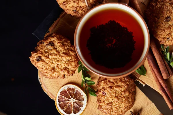 Bir fincan sıcak çay, kurabiye ve dekorasyon ahşap arka plan, seçici odak üzerinde bir oturum ile Noel kavramı