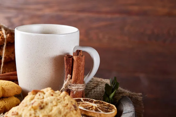 Tradizionale concetto di tè di Natale con una tazza di tè caldo, biscotti e decorazioni su uno sfondo di legno, focus selettivo — Foto Stock