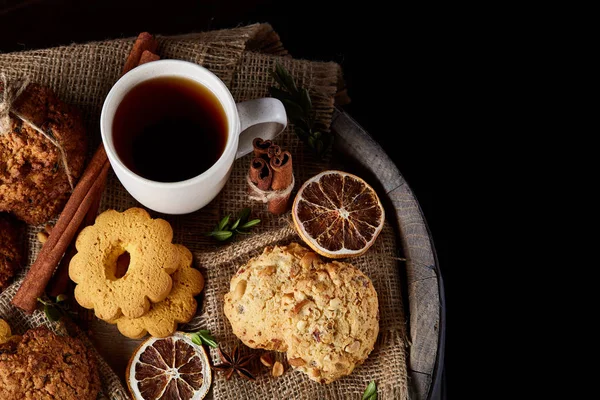 Traditionelles Konzept des Weihnachtstees mit einer Tasse heißem Tee, Plätzchen und Dekorationen auf Holzgrund, selektiver Fokus — Stockfoto
