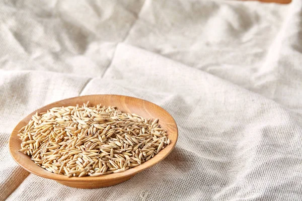 Yulaf kabuğu çıkarılmış tane veya yulaf ani artış ahşap plaka saf masa örtüsü arka plan, kopya alanı, üstten görünüm seçici odak üzerinde