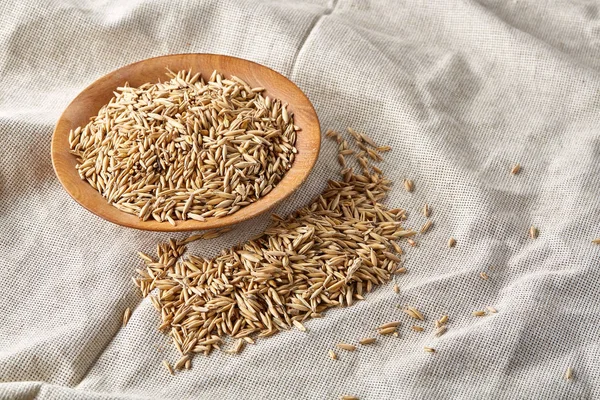 Yulaf kabuğu çıkarılmış tane veya yulaf ani artış ahşap plaka saf masa örtüsü arka plan, kopya alanı, üstten görünüm seçici odak üzerinde