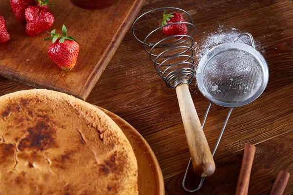 Lezzetli pasta kesme tahtası üzerinde ahşap arka plan, yakın çekim, selctive odak üzerinde taze organik çilek ile.