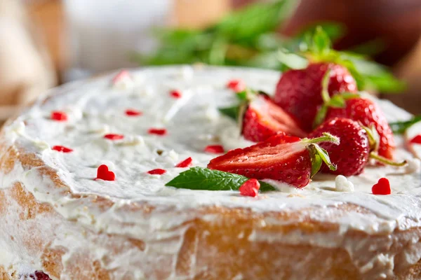 Çilekli tart ahşap arka plan üzerinde düz yatıyordu organik maddeler tarafından çevrili ekşi krem şanti ile kaplı.