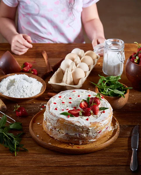 Kızlar el çilek pasta, yakın çekim, selctive odaklanmak, dikey koyarak üstten görünüm.