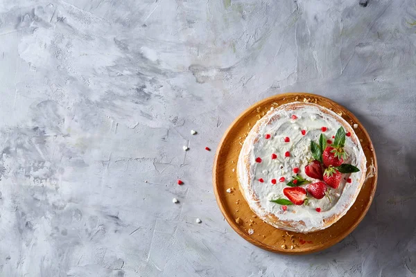 Çilek ve beyaz dokulu arka planda, seçici odak nane yaprakları ile süslenmiş krem şanti ile tart
