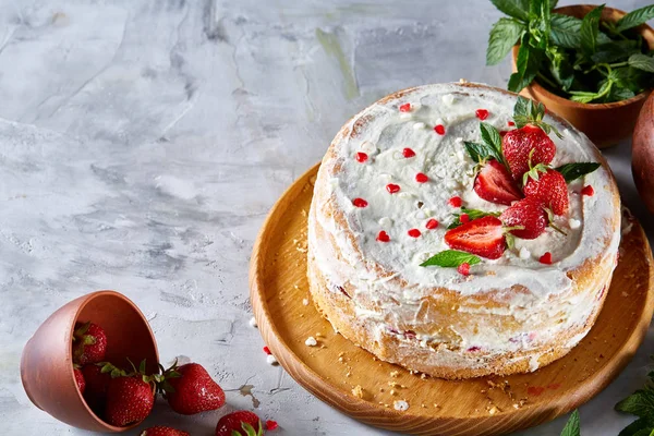 Çilek ve beyaz dokulu arka planda, seçici odak nane yaprakları ile süslenmiş krem şanti ile tart