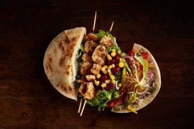 Tavuk, sebze ve ahşap arka plan, üstten görünüm, seçici odak Kebap Pide dolması.