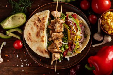 Ahşap arka plan, seçici odak üzerinde Kebap Pide, taze sebze ile egzotik hala slife.