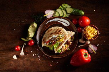 Doldurulmuş pide ve taze sebzelerin üzerine ahşap arka plan, seçici odak ile egzotik hala slife.