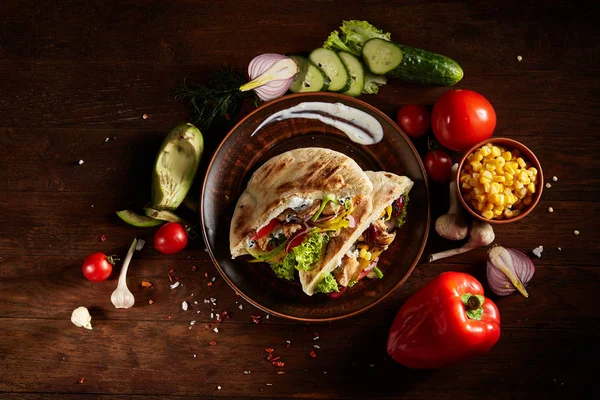 Doldurulmuş pide ve taze sebzelerin üzerine ahşap arka plan, seçici odak ile egzotik hala slife.