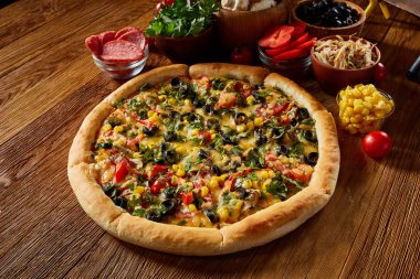 Pizza natürmort. Fırından yeni çıkmış pizza ve ahşap zemin üzerine düzenlenmiş bileşenleri.