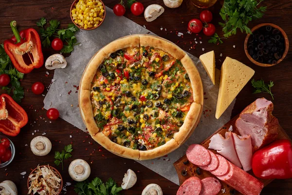 Pizza natürmort. Fırından yeni çıkmış pizza ve ahşap zemin üzerine düzenlenmiş bileşenleri.