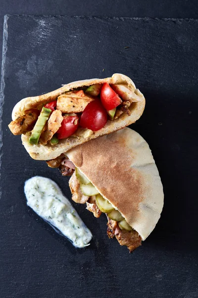 Doldurulmuş Pide ızgara sebze, domuz pirzola ve sos siyah taşlı arka planda, dikey.