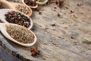 Renkli aromatik eski ahşap masa, yakın çekim, düz yemek pişirmek için çeşitli baharatlar yatıyordu, seçici odak.