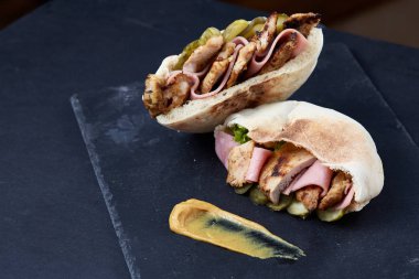 Doldurulmuş Pide ızgara sebze, domuz pirzola ve sos siyah taşlı arka planda, dikey.