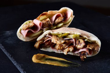 Doldurulmuş Pide ızgara sebze, domuz pirzola ve sos siyah taşlı arka planda, dikey.