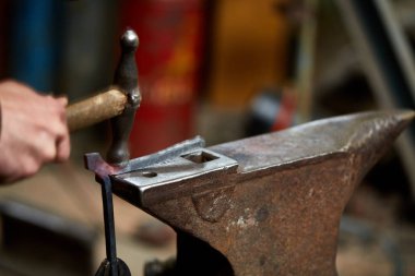 Onun forge, seçici odak üstünde metal bir parça işleme bir demirci elleri Close-up.