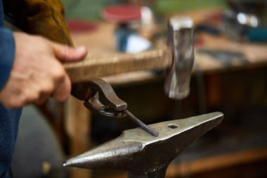 Onun forge, seçici odak üstünde metal bir parça işleme bir demirci elleri Close-up.