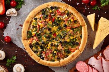 Pizza natürmort. Taze pişmiş pizza ve bileşenlerinin ahşap arka plan üzerine düzenlenmiş bir parçası.