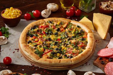 Pizza natürmort. Taze pişmiş pizza ve bileşenlerinin ahşap arka plan üzerine düzenlenmiş bir parçası.