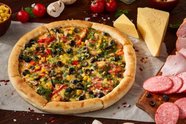 Pizza natürmort. Fırından yeni çıkmış pizza ve ahşap zemin üzerine düzenlenmiş bileşenleri.