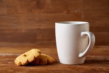 Ahşap ahşap arka plan, üstten görünüm, seçici odak parçası üzerinde çay ve tatlı kurabiye beyaz porselen kupa