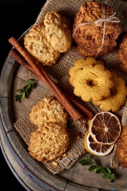 Tanımlama bilgileri ve tarçın ile ahşap bir varil, seçici odak peçeteye ürün çeşitliliği ile kavramsal kompozisyon