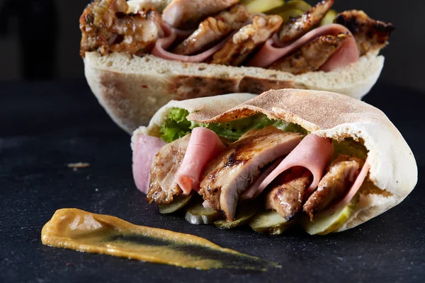 Doldurulmuş Pide ızgara sebze, domuz pirzola ve sos siyah taşlı arka planda, dikey.