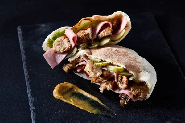 Doldurulmuş Pide ızgara sebze, domuz pirzola ve sos siyah taşlı arka planda, dikey.