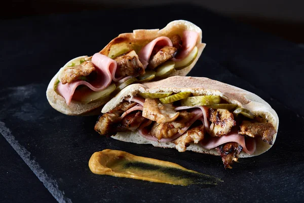 Doldurulmuş Pide ızgara sebze, domuz pirzola ve sos siyah taşlı arka planda, dikey.