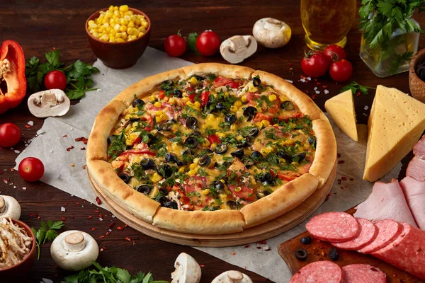 Pizza natürmort. Taze pişmiş pizza ve bileşenlerinin ahşap arka plan üzerine düzenlenmiş bir parçası.